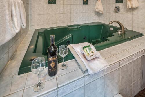a green sink with a bottle of wine and two glasses at Hotel Rose Garden in San Jose