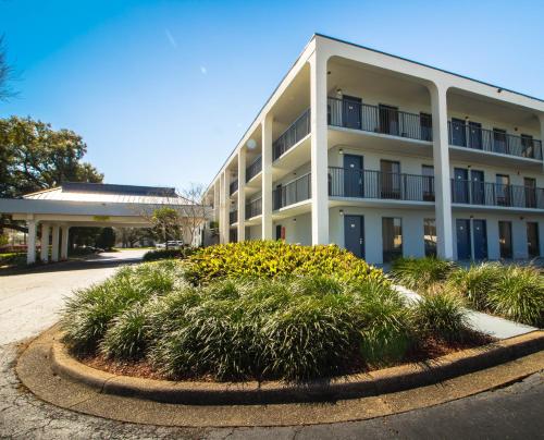 a large white building with plants in front of it at Sweet Dream Inn - University Park in Pensacola