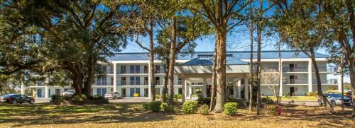 a large white building with trees in front of it at Sweet Dream Inn - University Park in Pensacola