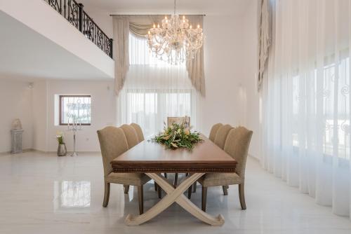 a dining room with a table with chairs and a chandelier at Villa Shangri-La Zakinthos in Zakynthos Town