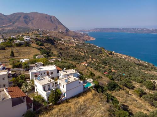 an aerial view of a house on a hill next to the water at Althea Maisonettes in Áptera