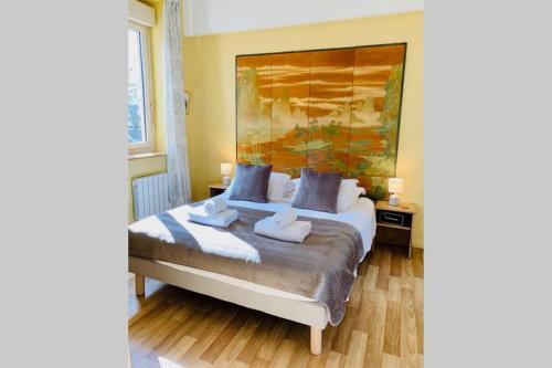 ボーヌにあるLe Petit Blanc - Vue sur le Square des Lionsの壁に大きな絵が飾られたベッドのある寝室