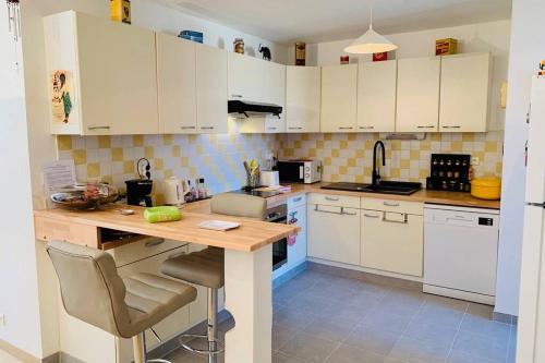 une cuisine avec des armoires blanches et un comptoir en bois dans l'établissement Le Petit Blanc - Vue sur le Square des Lions, à Beaune