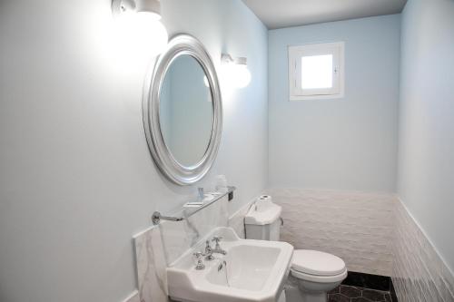 a bathroom with a sink and a toilet and a mirror at Auberge la Renaissance in Viarmes