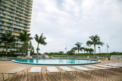 a swimming pool with lounge chairs and a building at Beachfront 2 Bed 2 Bath Penthouse Condo in Marco Island