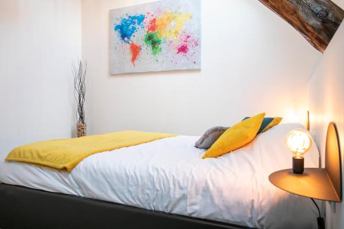 a bedroom with a bed and a painting on the wall at Chablis SPA : duplex Grand Cru in Chablis