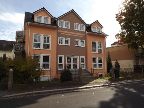 ein großes orangefarbenes Haus mit weißen Fenstern auf einer Straße in der Unterkunft Apartments und Zimmer Gästehaus Matthias in Dresden