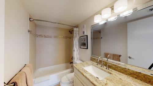 a bathroom with a sink and a toilet and a mirror at South Seas Tower 3 #1009 - Stunning 2/2 Beachfront Condo w/Endless Beach View in Marco Island