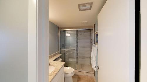 a bathroom with a shower and a toilet and a sink at Recently Renovated Beachfront Gem in Paradise! in Marco Island