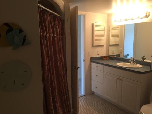 a bathroom with a sink and a shower curtain at Ideal for Conference @ J.W. Marriott / Access to Beach!! in Marco Island