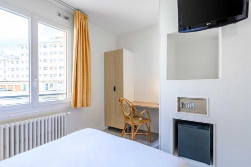a bedroom with a bed and a television and a chair at Comfort Hotel Rouen Alba in Rouen