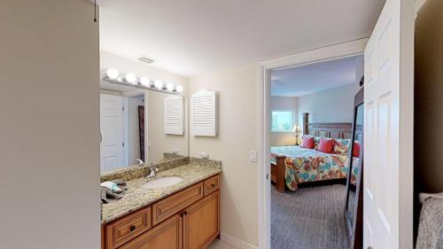 a bathroom with a sink and a bedroom with a bed at Top floor condo, steps away from JW Marriott and Beach Access!! in Marco Island