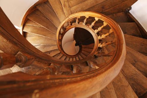 a wooden spiral staircase with a mirror in the middle at Villa Theresa à 25 min de PAIRI DAIZA in Soignies