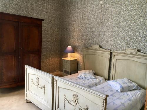 a bedroom with two beds and a lamp on a table at Villa Theresa à 25 min de PAIRI DAIZA in Soignies