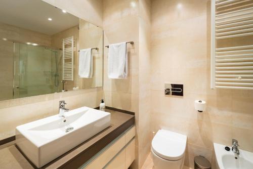 a bathroom with a white sink and a toilet at InSitges Center in Sitges