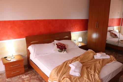 ein Schlafzimmer mit einem Bett mit einer Rose drauf in der Unterkunft Maremma Holidays - Cimarosa Apartment in Follonica