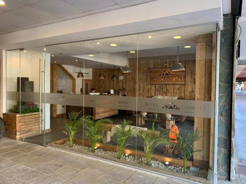 uma vitrine de um café com plantas nele em Entre Cumbres Hotel & Apart Hotel em Coihaique