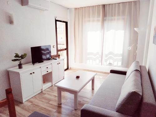 salon z kanapą, telewizorem i stołem w obiekcie Apartamento Ronda 4 - Los Boliches w mieście Fuengirola