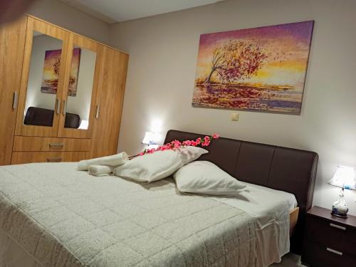um quarto com uma cama com flores cor-de-rosa em Central Square Apartment 1 em Pirgos