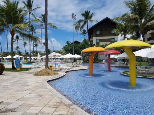 ein Pool mit Sonnenschirmen in einem Resort in der Unterkunft Flat Marulhos Resort in Porto De Galinhas
