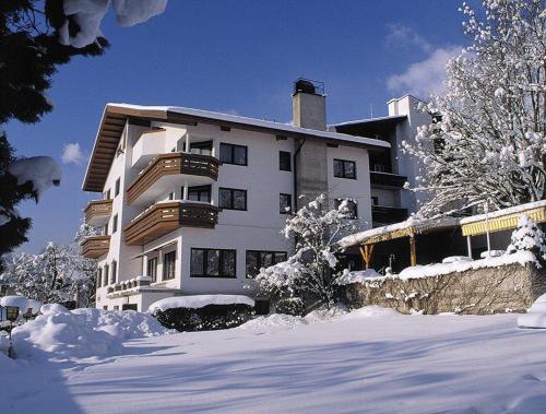 a large white building with snow on the ground at Hotel-Garni Stern - bed & breakfast & more in Imst