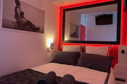 - une chambre avec un lit à éclairage rouge dans l'établissement Naturiste Cap d'Agde Port Nature 869, au Cap d'Agde