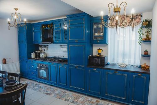a blue kitchen with blue cabinets and a stove at La Contessa Apartament in Tîrgu Neamţ