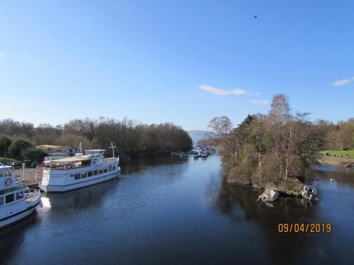 two boats are docked on a river at Levenview Holiday Apartment Loch Lom in Balloch
