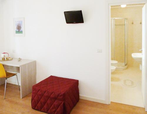 - une salle de bains avec un pouf rouge dans l'angle de la chambre dans l'établissement Il Cantico B&B, à Capurso