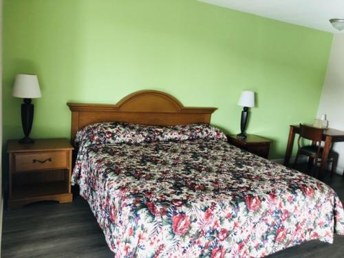 a bedroom with a bed and two lamps and a table at Flamingo Beach Inn in Biloxi