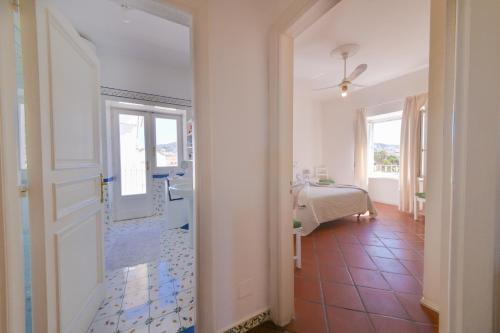 Un pasillo con una puerta que conduce a un dormitorio. en Casa Romano, centro di Forio, Ischia, en Isquia