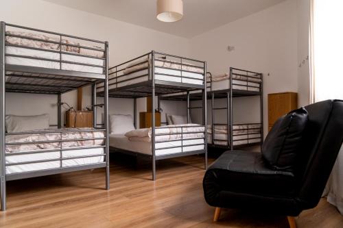 a living room with three bunk beds and a chair at OceanOasis in Olhão