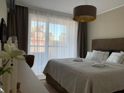 a bedroom with a bed and a large window at Central Point by Zoom Apartments in Bratislava