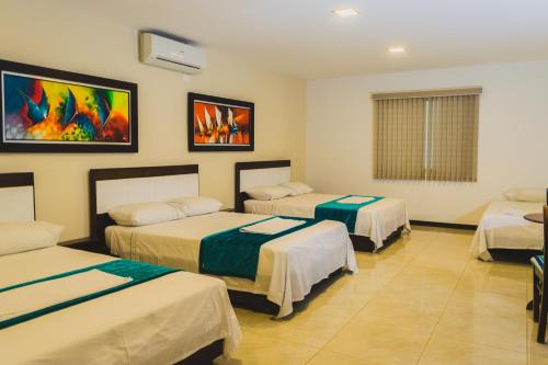 una habitación de hotel con 3 camas en una habitación en Hotel Manantial, en Buga