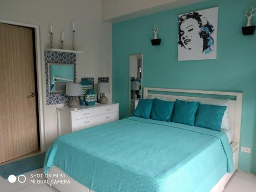 una camera da letto con un letto con lenzuola blu e uno specchio di Lagoon view Family Suite in Pico De Loro Cove, Nasugbu a Nasugbu