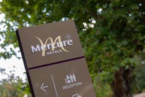 a sign for the mercier hotel with trees in the background at Mercure Orange in Orange