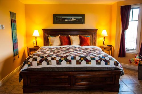 a bedroom with a bed with orange walls and two lamps at The Artisan Suites in Hopewell Cape