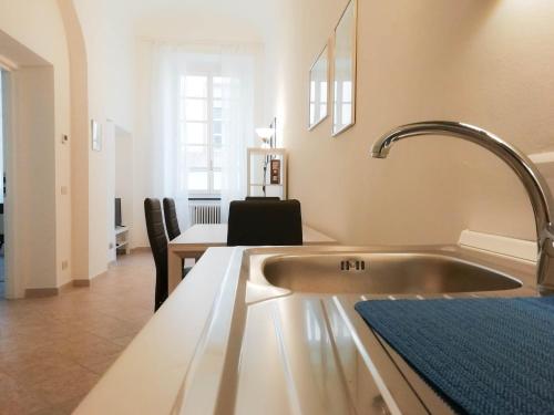 kuchnia ze zlewem i stołem z krzesłami w obiekcie MistrangeloHome 5 - Appartamento in Pieno Centro w mieście Savona
