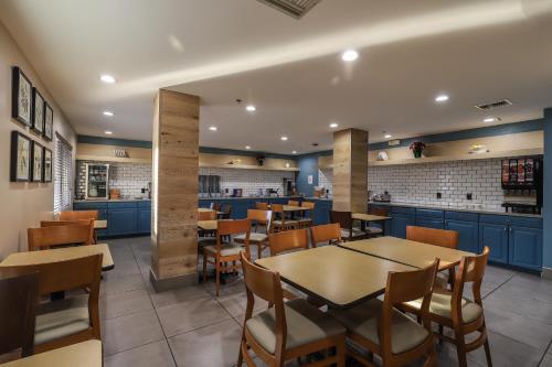 a restaurant with blue cabinets and a table and chairs at Wingate by Wyndham Chandler Phoenix in Chandler