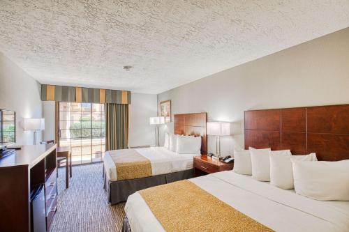 a hotel room with two beds and a television at Best Western Green Valley Inn in Green Valley