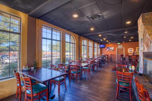 Best Western Green Valley Inn في جرين فالي: مطعم به طاولات وكراسي ونوافذ