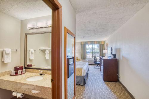 a hotel room with a bathroom with a bed and a mirror at Best Western Green Valley Inn in Green Valley