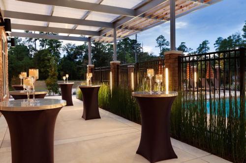 a patio with bar stools and a fence at Hyatt Place Houston/The Woodlands in The Woodlands