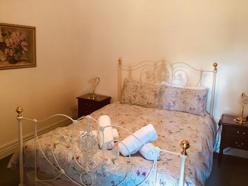 a bedroom with a bed with two rolls of toilet paper on it at The OldDevonshire House in Mintaro