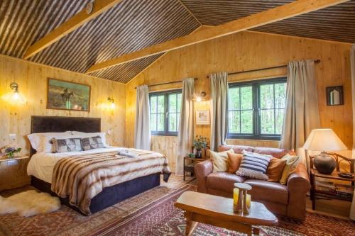 a bedroom with a bed and a couch at Off-Grid Relaxing Getaway at The Captain's Rest in Clachan of Campsie