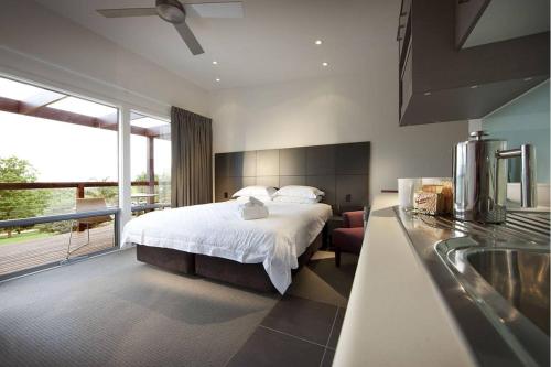 a bedroom with a bed and a kitchen with a sink at Longview Vineyard in Macclesfield