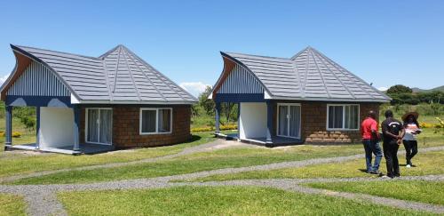 a group of people standing in front of two houses at VICTORIA SANDS LODGE in Mbita