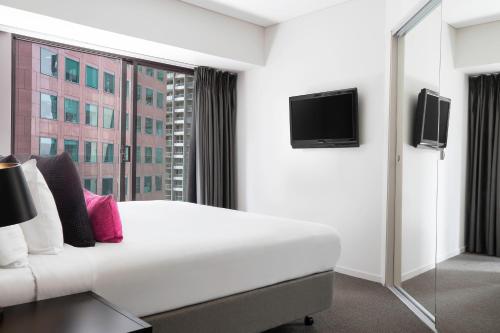 a hotel room with a bed and a tv at Mantra Southbank in Melbourne