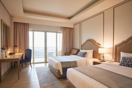 una camera d'albergo con due letti, una scrivania e una finestra di Twin Lakes Hotel a Tagaytay