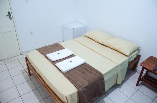 a bedroom with a bed with two towels on it at HOTEL XENIOS in Macapá